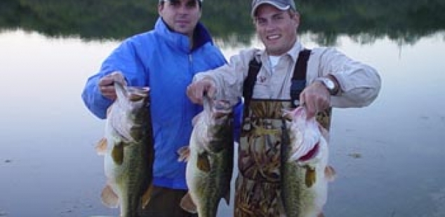 Derek Stratton and Bradford Bryant hold 3 nice bass being transferred from the large lake to the small lake at San Saba Waco Creek Ranch